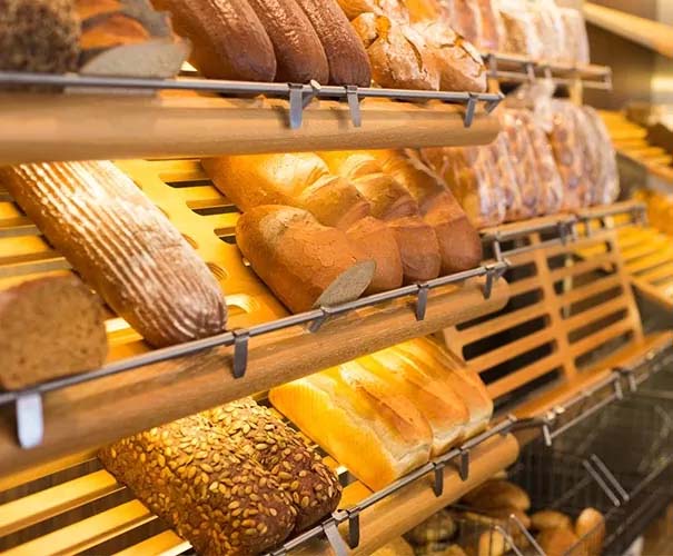 Warm bakery shelves illuminated with golden LED light bars highlighting fresh loaves and pastries in a display cabinet. Warm bakery shelves illuminated with golden LED light bars highlighting fresh loaves and pastries in a display cabinet.