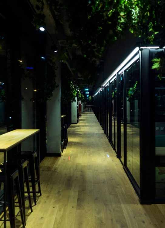 Modern commercial corridor with LED strip lighting along glass partitions, creating a clean and low-glare lighting effect.