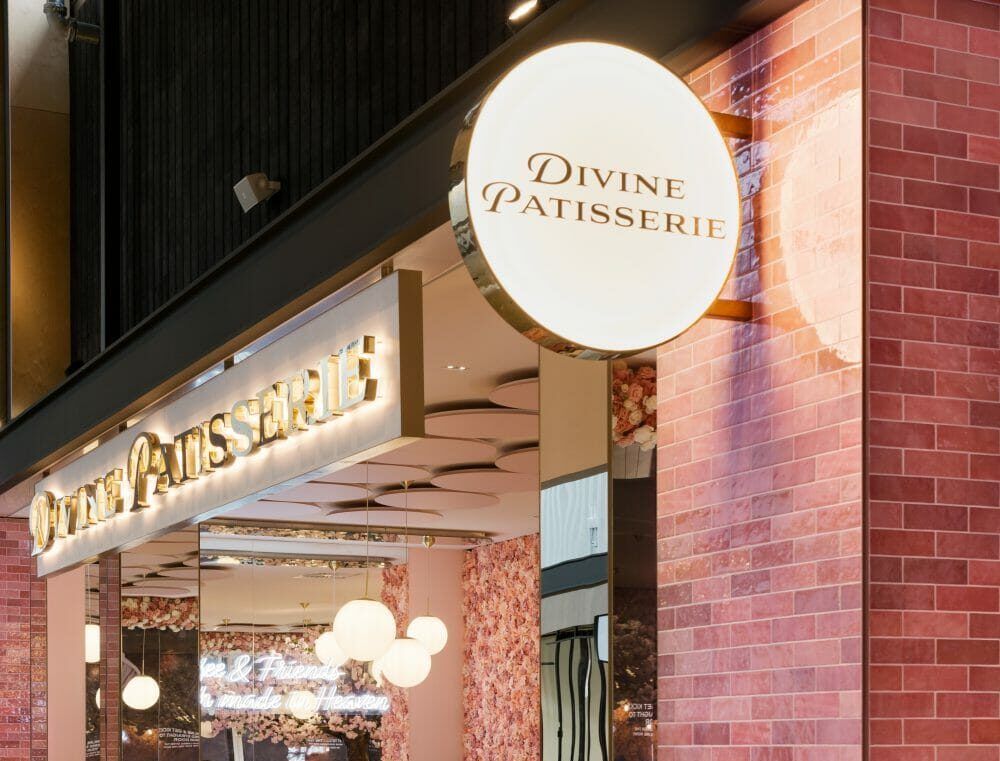 Illuminated gold signage lighting a retail frontage in Ormiston Town Centre, Auckland, visible to shoppers in daylight Illuminated gold signage lighting a retail frontage in Ormiston Town Centre, Auckland, visible to shoppers in daylight